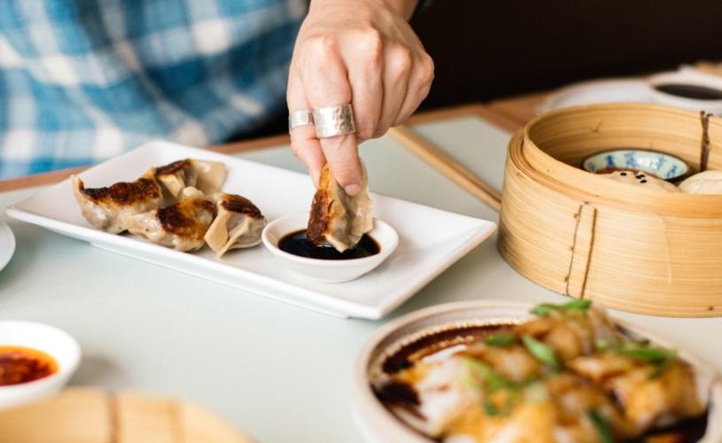 Person dipping dumpling in sauce - credit Clouds Bristol