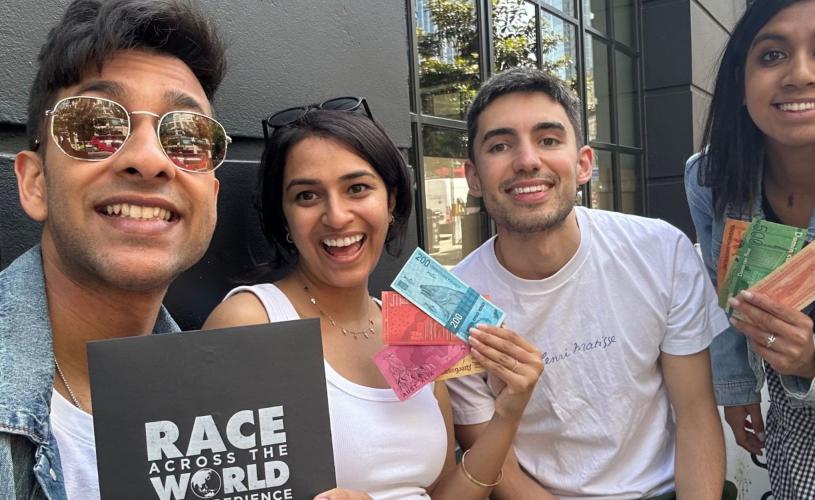 Group posing with items from Race Across the World: The Experience