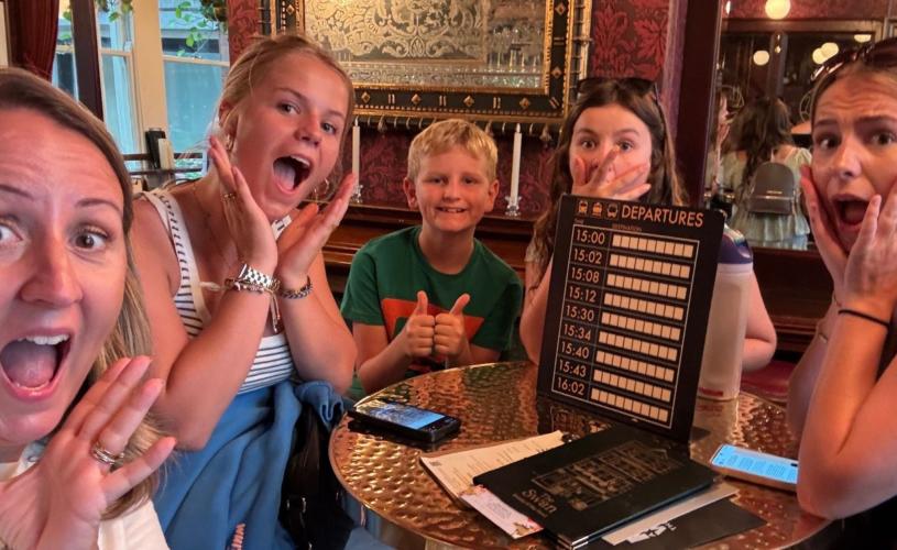 Family posing with items from Race Across the World: The Experience