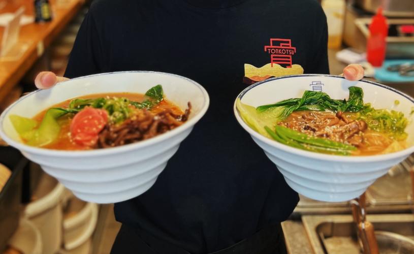 Person holding two bowls of ramen - credit Tonkotsu