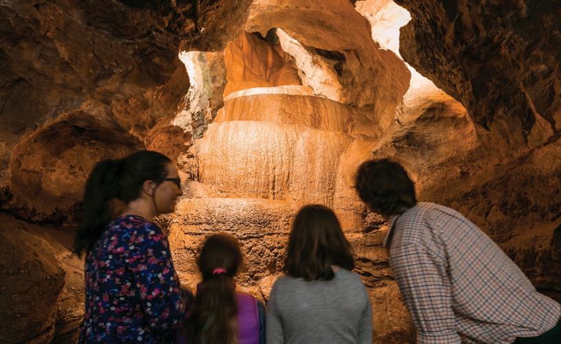 A family exploring the interior of the caves at Cheddar Gorge & Caves near Bristol - credit Cheddar Gorge & Caves