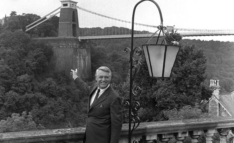 A black and white image of Cary Grant pointing at the Clifton Suspension Bridge from the Avon Gorge Hotel in West Bristol - credit Bristol Post