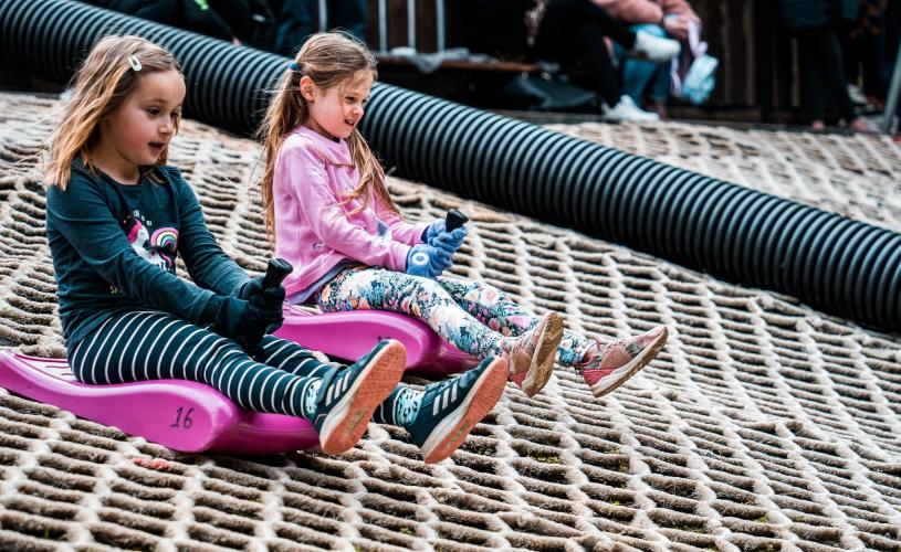 Children tobogganing on the slope at Mendip Activity Centre, near Bristol - credit Mendip Activity Centre