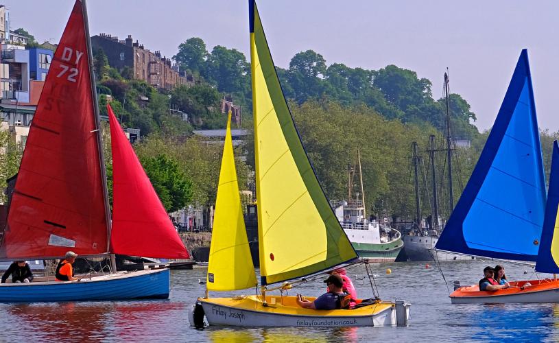 Three colourful sailboats in the Bristol Harbourside - Credit All Aboard Watersports