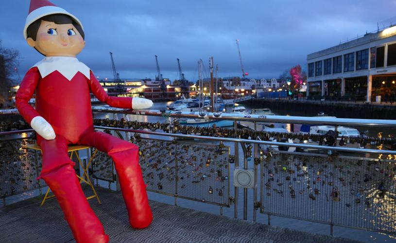 A giant inflated elf sat on a bridge - Credit Plaster