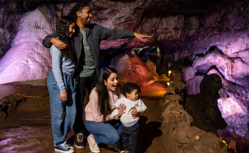 A family in a cave at Wookey Hole in Wells, near Bristol - credit Wookey Hole