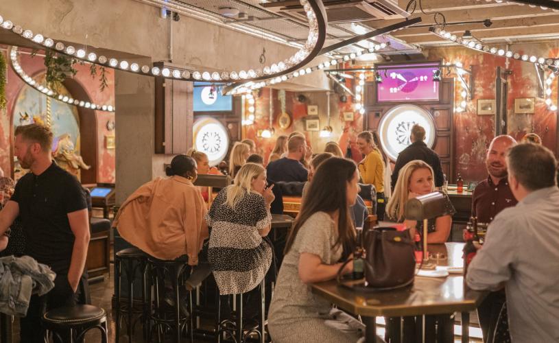 People sat at tables at Flight Club Bristol - credit Flight Club