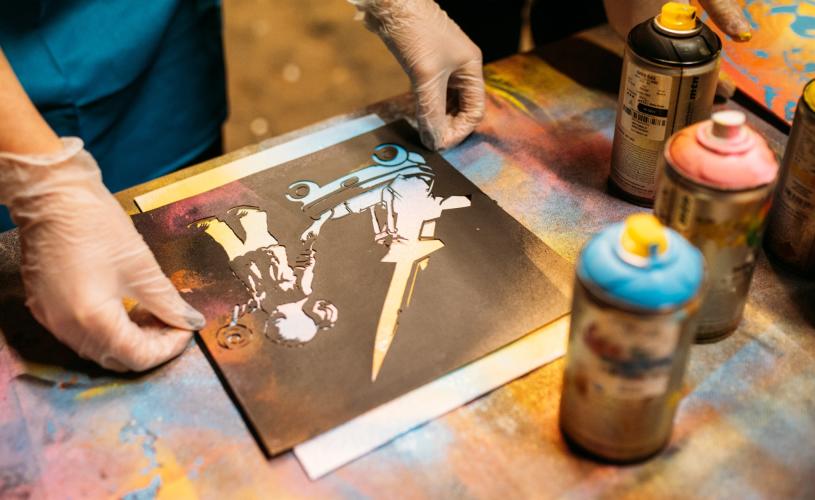 A person lining up a canvas before spraying paint at Graft Bristol - credit Yuup