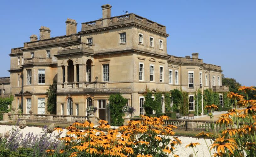 External shot of Hartham Park country house with flowers blooming in the foreground.