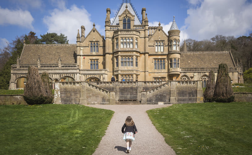 Gothic mansion house with girl running in front - credit Rob Stothard, National Trust