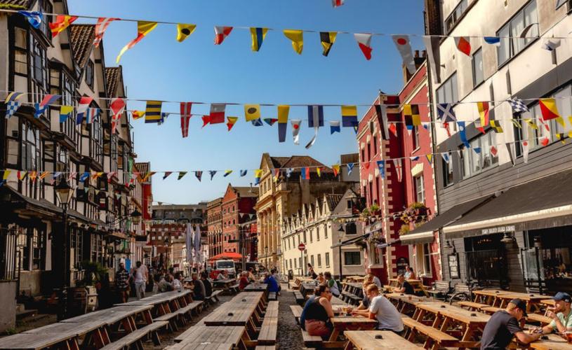 A view of the eastern end of King Street in central Bristol, with the historic Llandoger Trow pub on the left and the modern King Street Brew House on the right