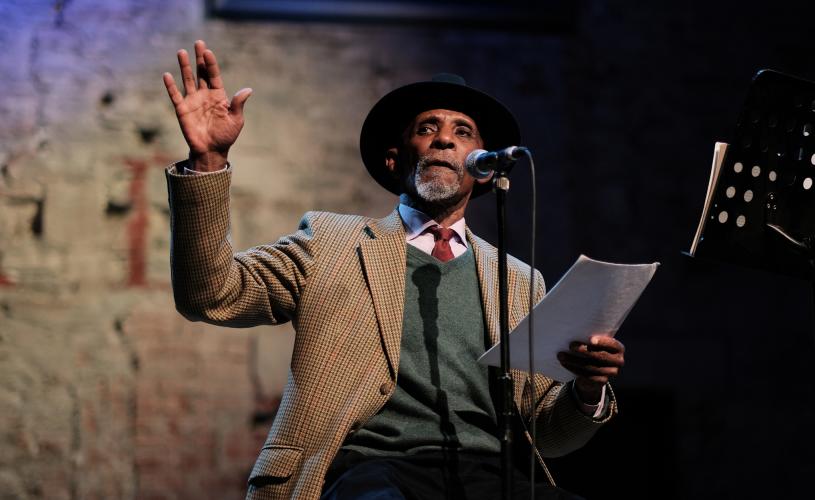 A man performing on stage at Lyra Poetry Festival - Credit Sam Cavender