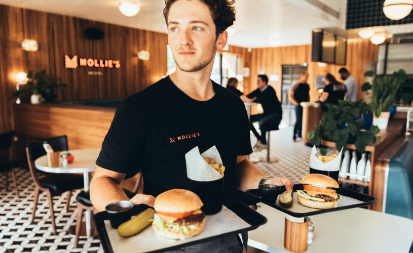 Person carrying burgers at Mollies Motel & Diner Bar in North Bristol - credit Mollies Motel & Diner Bar