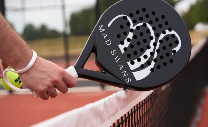 A black pickleball paddle with a white swan on it and Mad Swans written on it