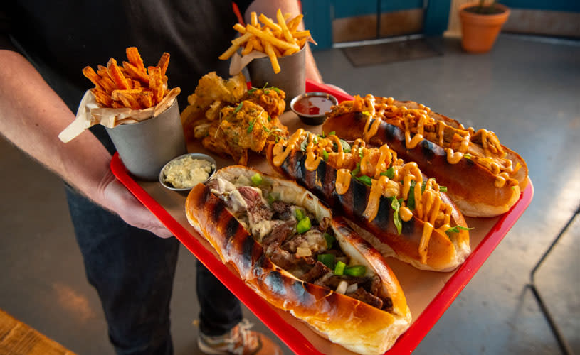 A red tray full of hot dogs and sweet potato fries - Credit Quay Street Diner