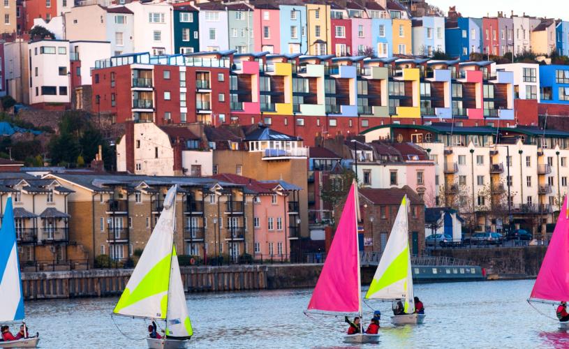 A view of small sailboats on Bristol's Harbourside with the colourful houses of Cliftonwood in the background - credit Paul Box