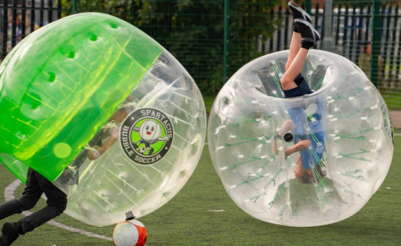 Two boys inside a zorb bubble playing football at Spartacus Bubble Soccer