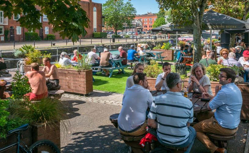 People sitting outdoors under the sun by The Ostrich pub in the Redcliffe area of Bristol - credit Mahtola Eagle