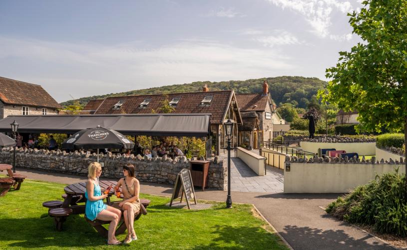 People sitting outside under the sun next to the Railway Inn at Thatchers Cider HQ in Sandford, near Bristol - credit Thatchers