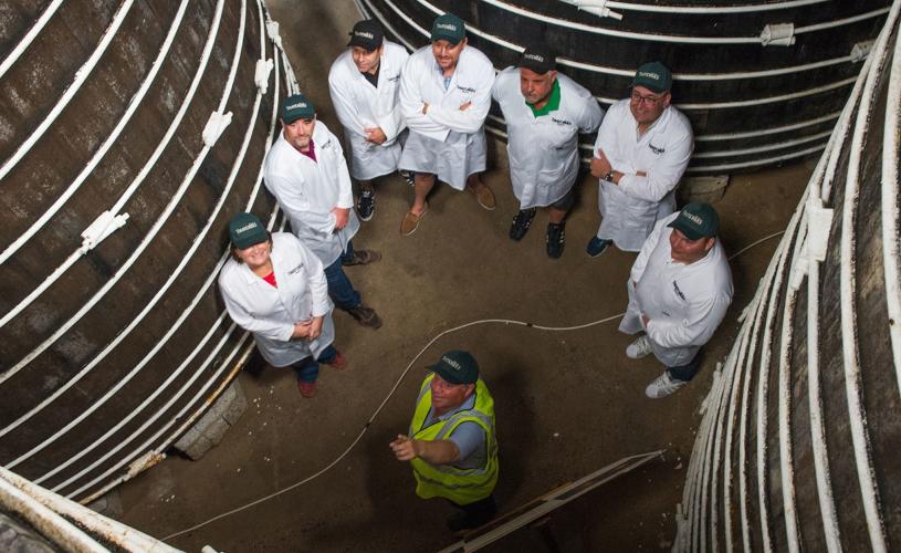 Tour group next to cider barrels at Myrtle Farm, near Bristol - credit Thatchers Cider