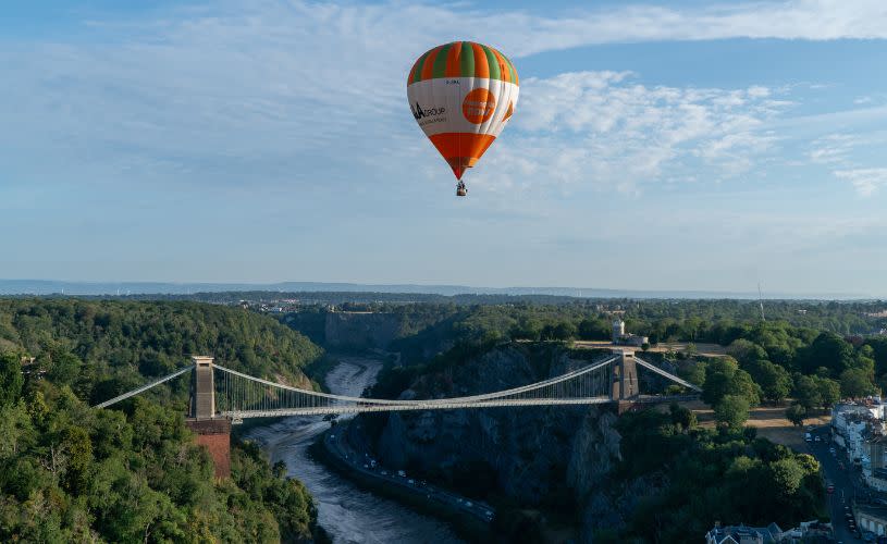 A green and orange striped balloon over the Clifton Suspension Bridge
