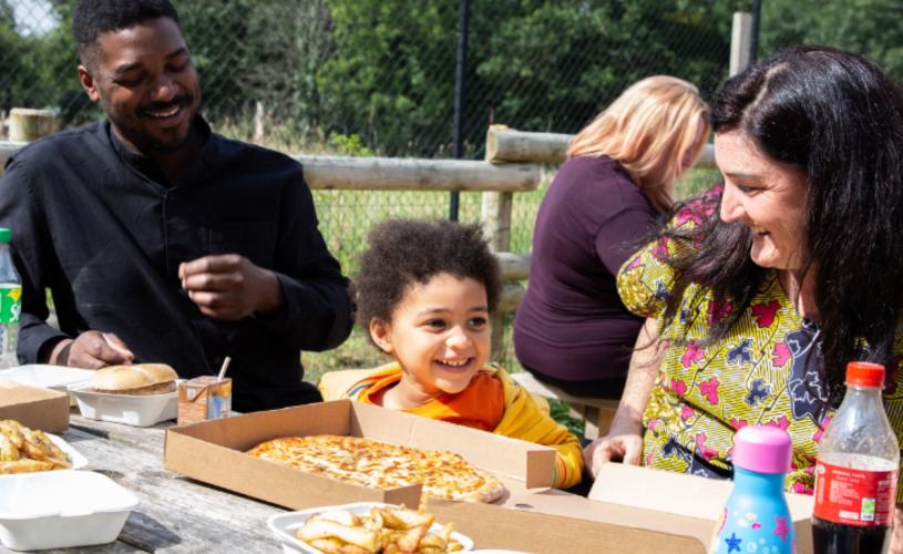 Family eating pizza and wedges at Basecamp Pizzeria in Bristol Zoo Project in the winter - credit Bristol Zoo Project