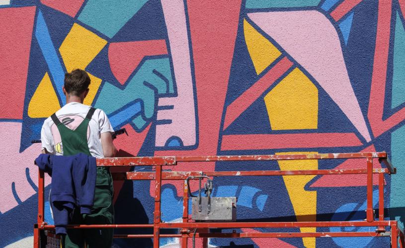 Artist painting a mural at Upfest street art festival in Bristol