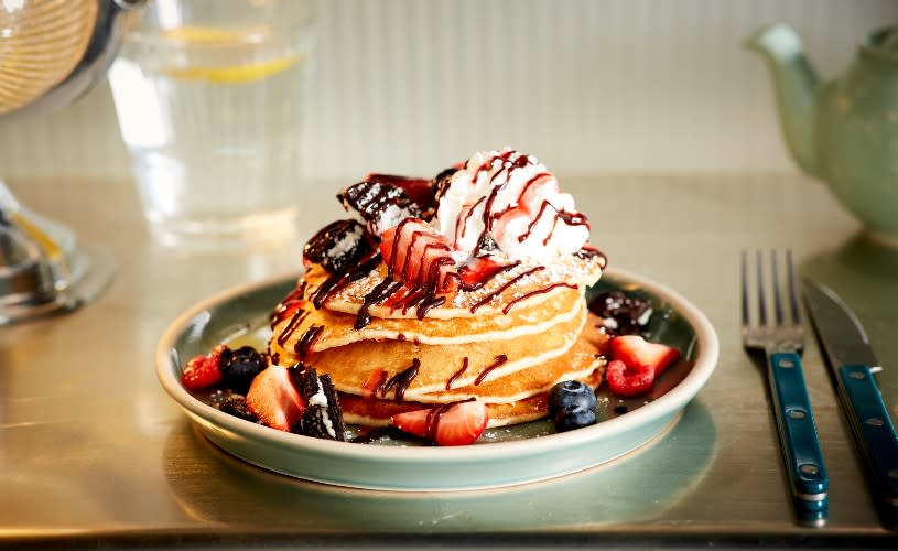 A stack of pancakes with berries and whipped cream - Credit Mollie's Motel and Diner