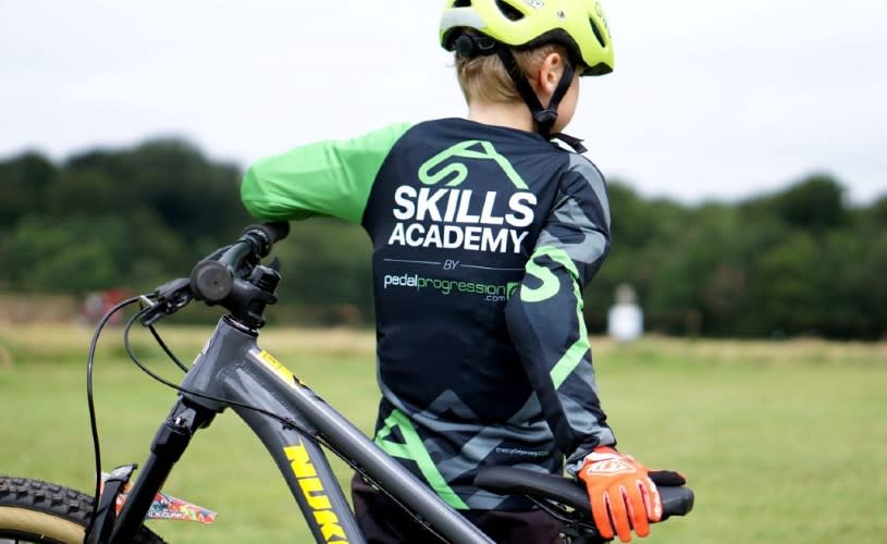 Teenager stood next to bike wearing Skills Academy shirt - credit Pedal Progression