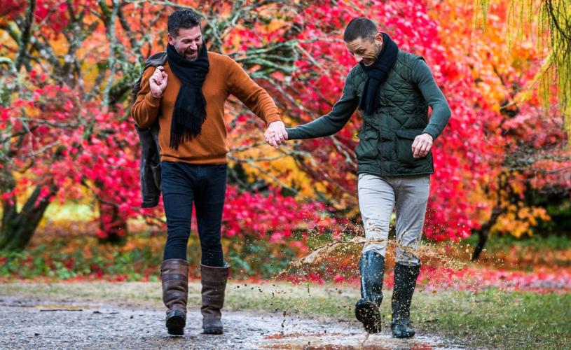 A male couple walking through the grounds of Westonbirt Arboretum in autumn - credit Johnny Hathaway