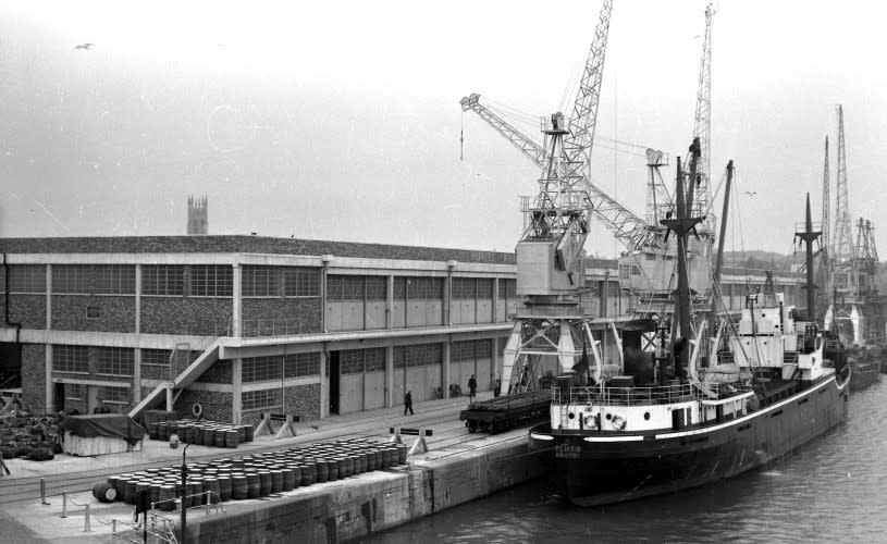 A black and white image of Pluto being loaded at Princes Wharf in 1957 - Credit Visit West