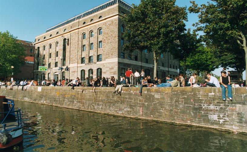 People sat on the harbourside wall outside of the Arnolfini - Credit Arnolfini