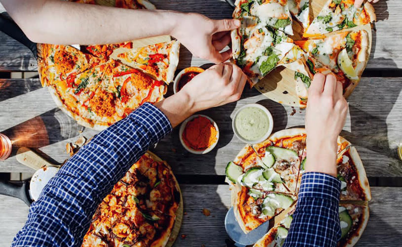 A selection of pizza on a wooden table - Credit The Stable