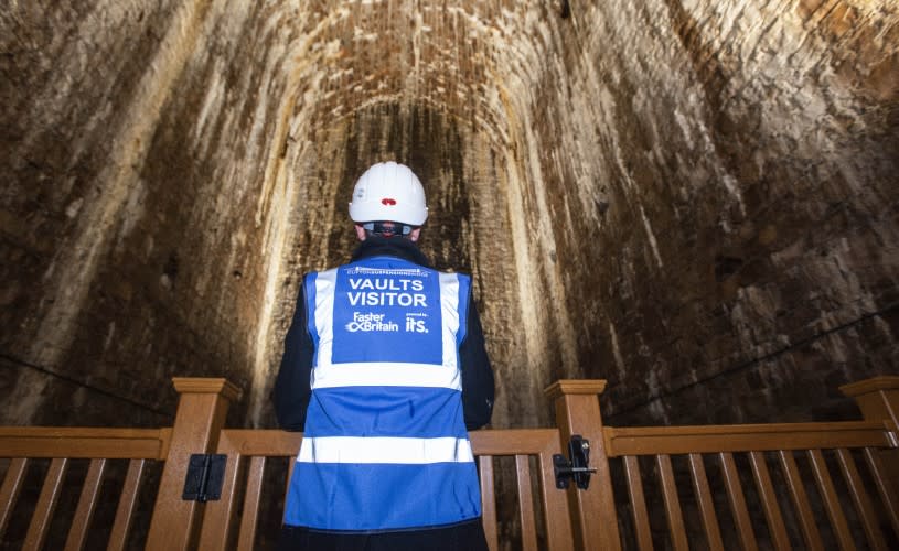 A person wearing a blue hi vis jacket and a white hard hat inside one of the pillars of the Clifton Suspension Bridge - Credit Clifton Suspension Bridge Trust