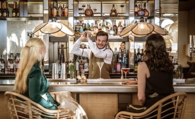 A barman serving two women cocktails at Ricks Bar Bristol