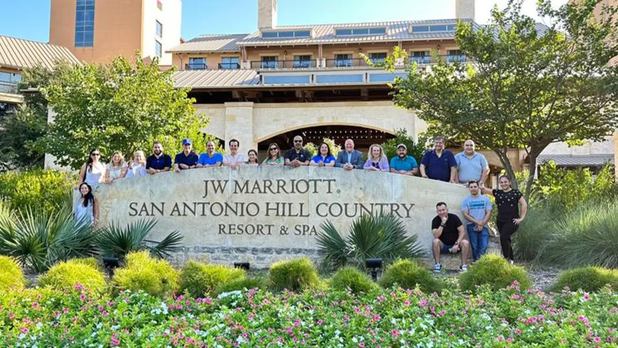 Group of professionals in front of exterior JW Marriott San Antonio Hill Country signage