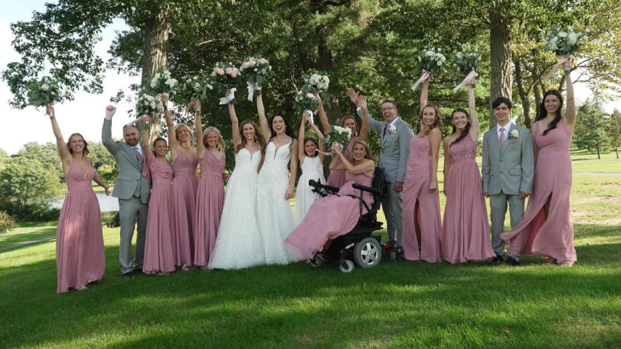 Large bridal posing outside with arms raised