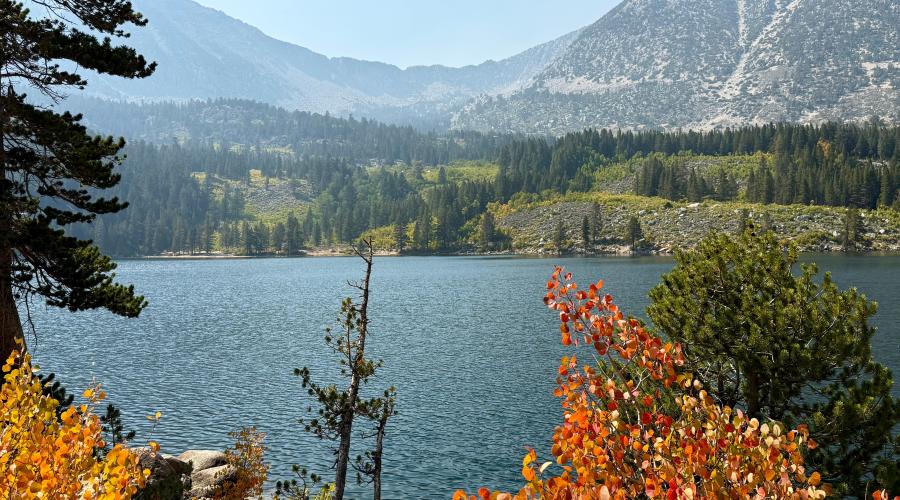 A view of Rock Creek Lake with patches of fall color orange in the frame.