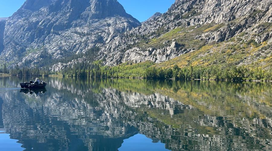 a boat on the water at Silver Lake, with a backdrop green and yellow aspen and Carson Peak