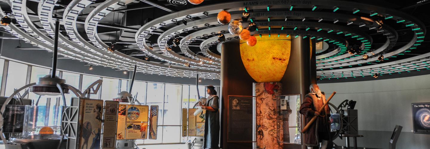 Statues and a large mobile model of the solar system are part of an exhibit at LASM.