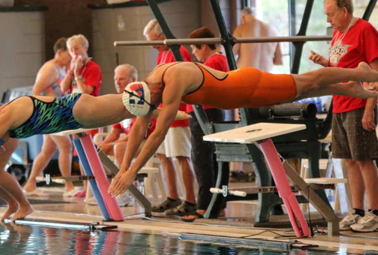Swimmers diving into pool at Huntsman Senior Games