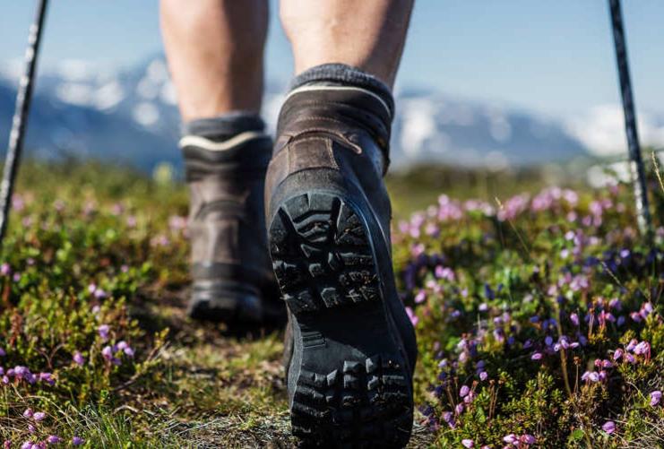 View of hiker's boots walking a long a green trail