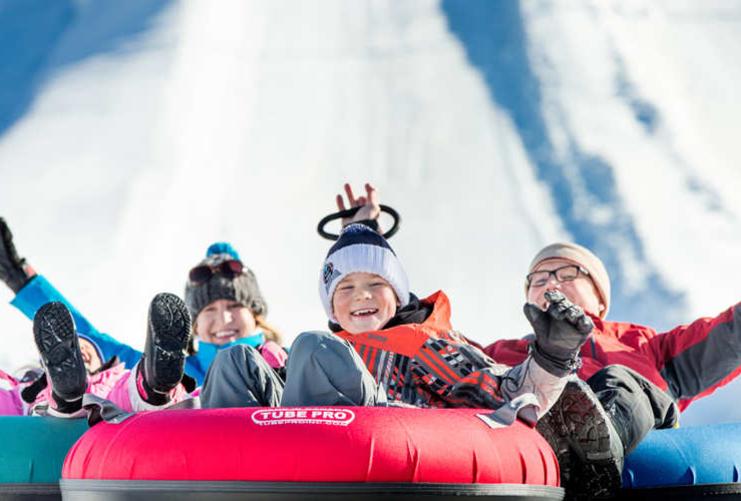 Children tubing down a snowy hill