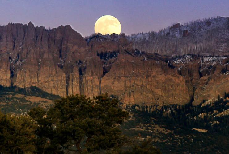 Full moon rising over mountains by Panguitch UT