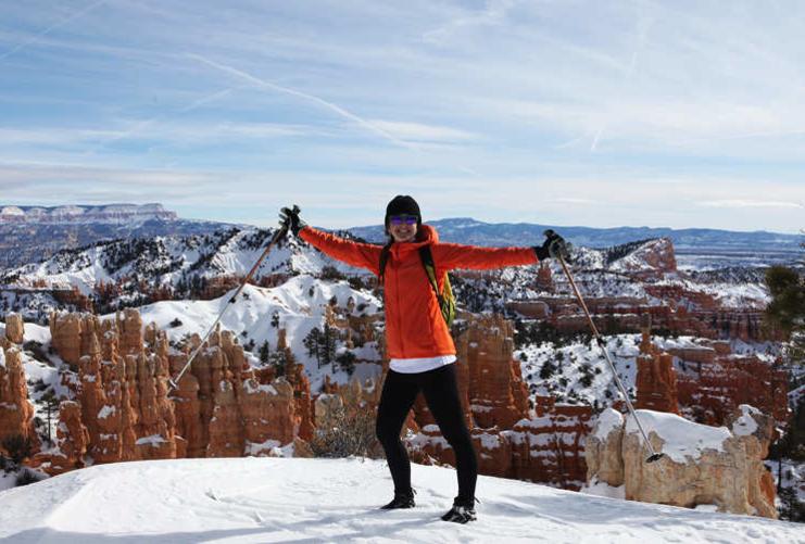 Hiker in red coat in the snow at Bryce Canyon