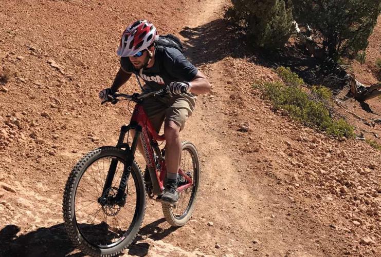 Male biker pedaling up a hill at Thunder Mountain Trailhead