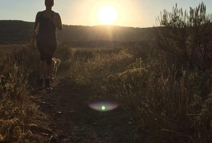 Woman running on trail with dog