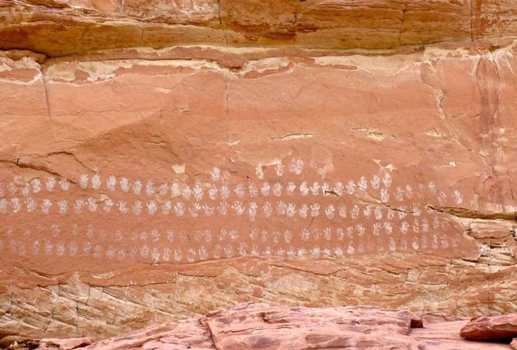 The hundred hands pictograph near Boulder Utah. Native American rock art with 100 white handprints on the sandstone wall.