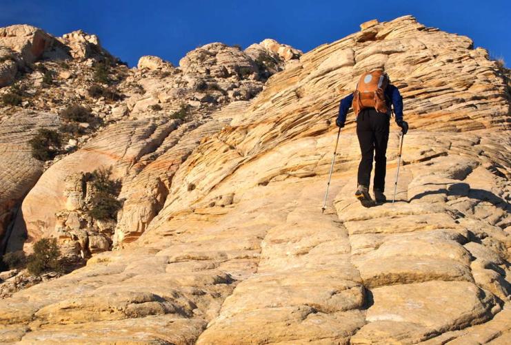 Hiker walking up a rocky hill near Boulder Utah