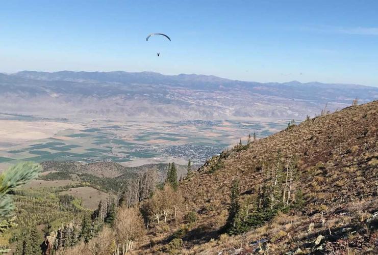 Picture of a paraglider in the mountains by farming community